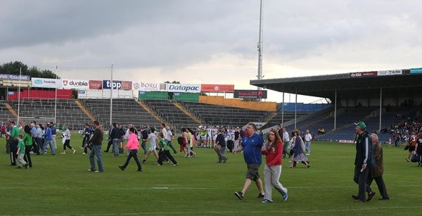 Supporters arriving late run across the pitch before a delayed throw in 23/7/2013