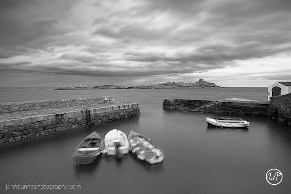 Some small fishing boats are safely moored in Coliemore Harbour as the seas around Dalkey Island are swept up by a stiffening breeze and storm clouds move in overhead.