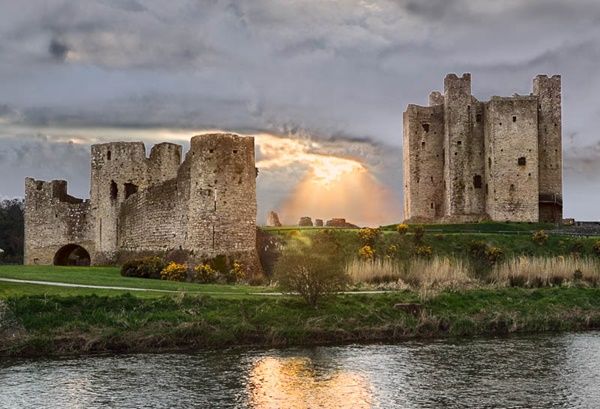 A view of the river Boyne and Trim Castle at sunset. Trim Castle is the largest Anglo-Norman castle in Ireland. It was constructed over a thirty-year period by Hugh de Lacy. Hugh de Lacy was granted the Liberty of Meath by King Henry II in 1172 in an attempt to curb the expansionist policies of Richard de Clare, (Strongbow). Construction of the massive three storied Keep, the central stronghold of the castle, was begun c. 1176 on the site of an earlier wooden fortress. This massive twenty-sided tower, which is cruciform in shape, was protected by a ditch, curtain wall and moat.