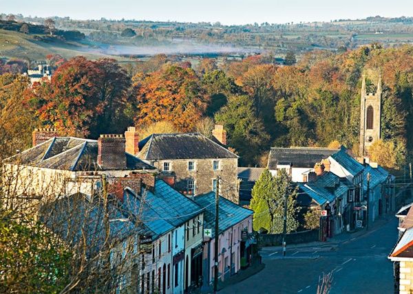 A frosty early morning view of Slane village in late Autumn.   To the right of the photograph is the steeple of St Patrick's church.  To the left of the image, behind the trees, Slane Castle can be seen.