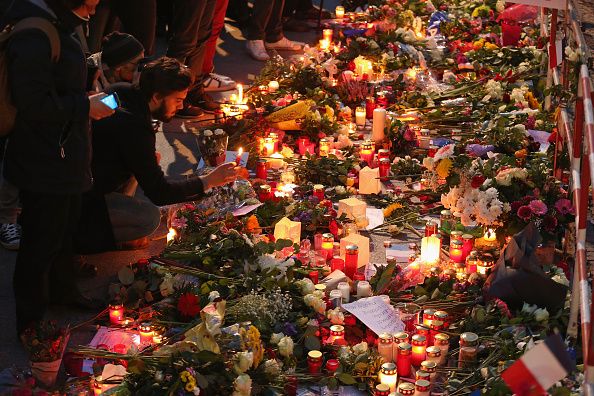 BERLIN, GERMANY - NOVEMBER 14: People arrive to lay candles and flowers at the gate of the French Embassy following the recent terror attacks in Paris on November 14, 2015 in Berlin, Germany. Hundreds of people came throughout the day to lay flowers, candles and messages of condolence to mourn the victims of attacks last night in Paris that left at least 120 people dead across the French capital. The Islamic State (IS) has claimed responsibility for the attacks that were carried out by at least eight terrorists. (Photo by Sean Gallup/Getty Images)
