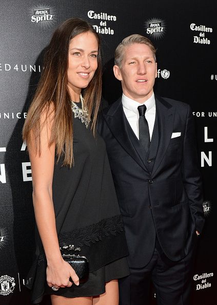 Manchester United's German midfielder Bastian Schweinsteiger (R) and his girlfriend, tennis player Ana Ivanovic pose for pictures on the red carpet as they arrive to attend the "United for UNICEF Gala Dinner" at Old Trafford in Manchester, north-west England, on November 29, 2015. AFP PHOTO / OLI SCARFF / AFP / OLI SCARFF (Photo credit should read OLI SCARFF/AFP/Getty Images)