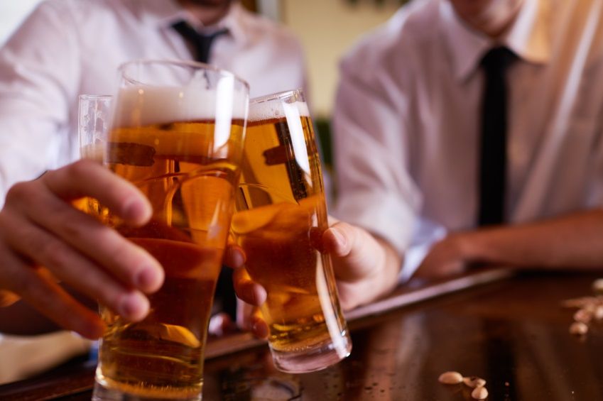 Three men toasting with beer at pub