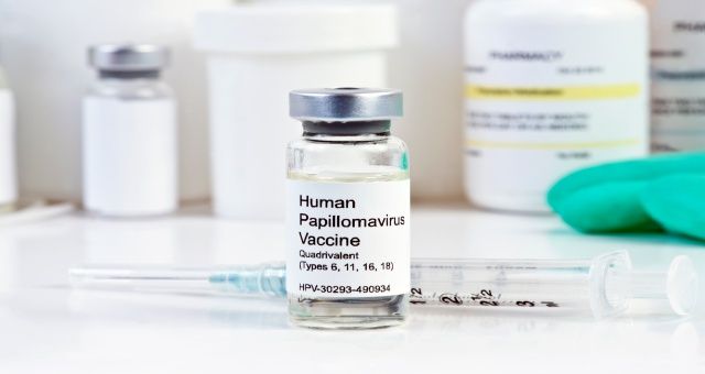 Human Papilloma Virus vaccine with syringe in vial at a clinic. Labels and/or document is completely fictitious. Any serial numbers/names/codes/dates are totally random and any resemblance to any actual product is purely coincidental.