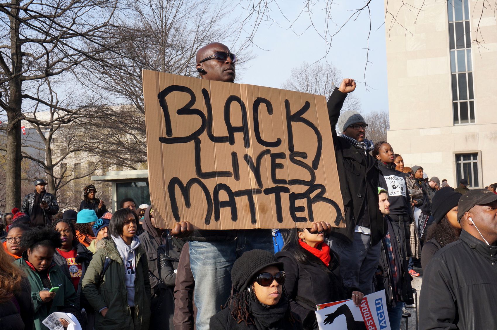 Washington DC, USA-December 13, 2014: This man is protesting police brutality at a protest led by Reverend Al Sharpton on Pennsylvania Avenue in Washington DC. He displays a sign with the message Black Lives Matter. Recently the deaths of Michael Brown, Eric Garner and Tamir Rice have upset the black community.