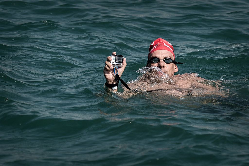 A participant uses a camera protected with a waterproof case as he swims across Victoria Harbour in Hong Kong on October 6, 2013. Two thousand swimmers took one of the world's busiest waterways to compete in a gruelling cross-harbour contest, replacing normal harbour traffic of ferries and cargo boats. AFP PHOTO / Philippe Lopez (Photo credit should read PHILIPPE LOPEZ/AFP/Getty Images)