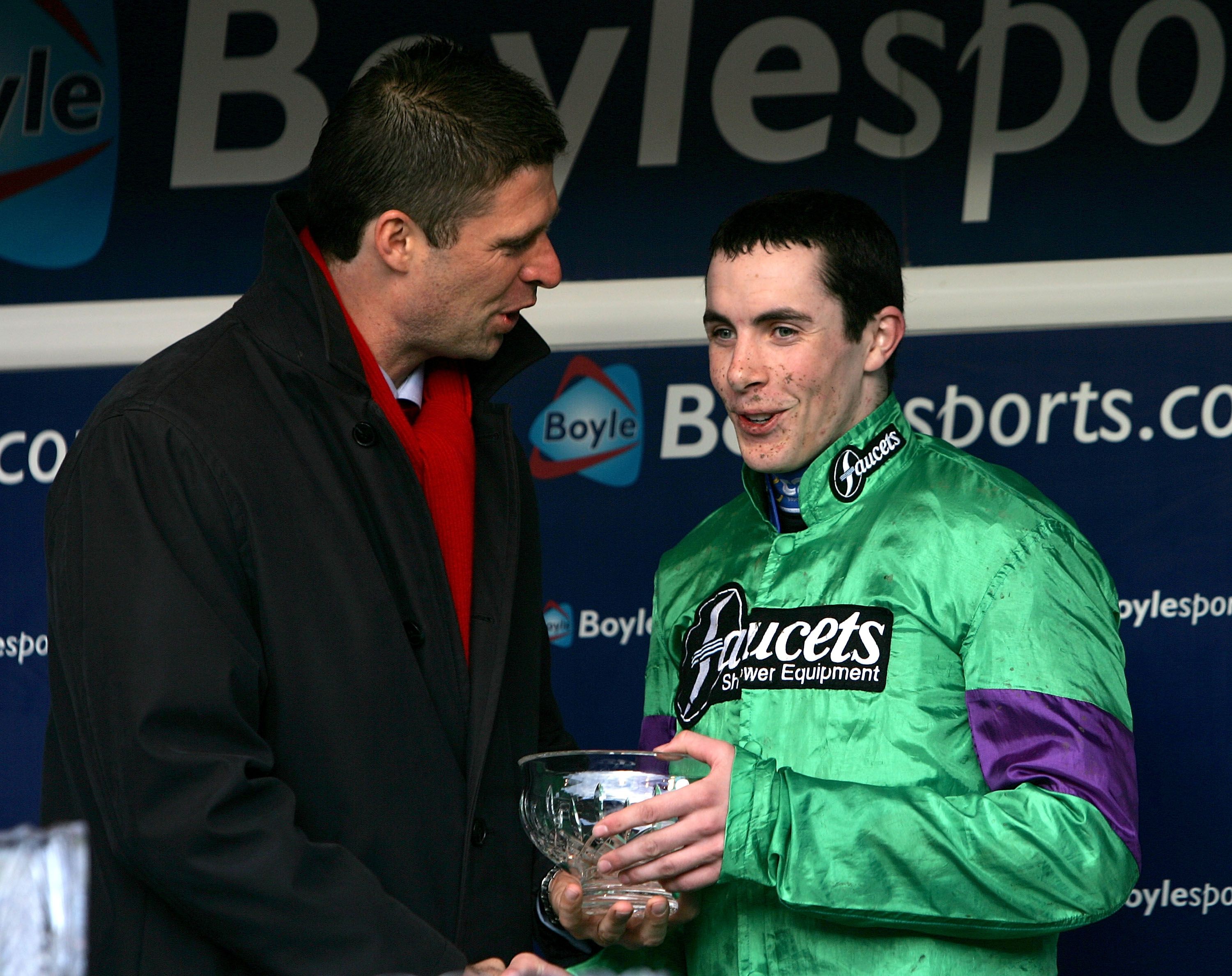 CHELTENHAM, UNITED KINGDOM - DECEMBER 12: Niall Quinn of Sunderland Football Club presents Aidan Coleman with his trophy after he wins The Boylepoker.com Steeple Chase at Cheltenham Racecourse on December 12, 2008 in Cheltenham, England. (Photo by Christopher Lee/Getty Images)